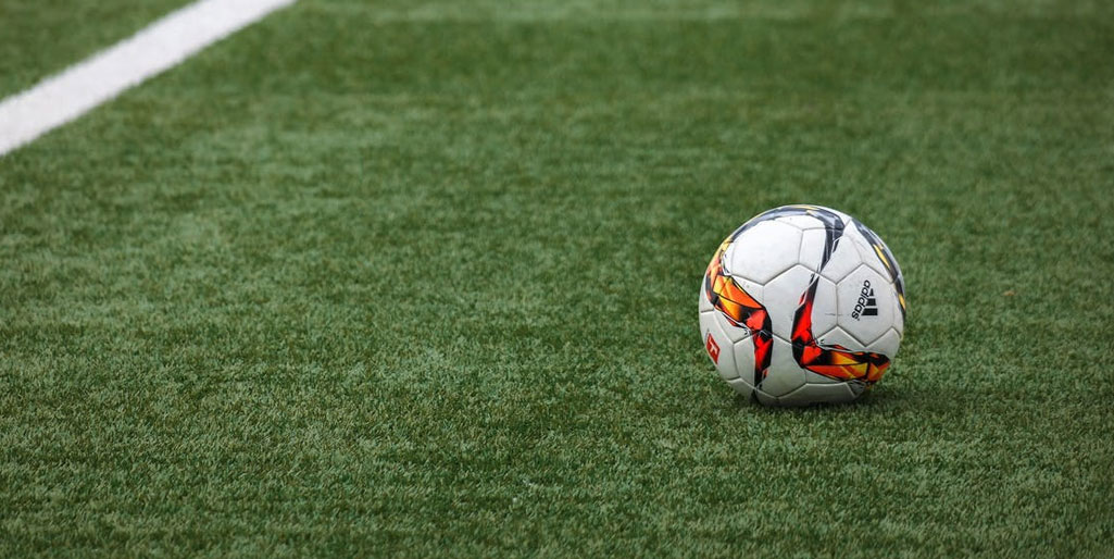 Football on a pitch representing Ligue 1 editorial localisation for Latin American fans