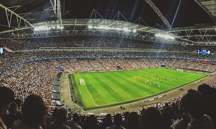 A packed football stadium under floodlights